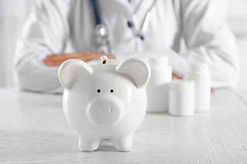 © Africa Studio - stock.adobe.com Arzt hinter Sparschwein